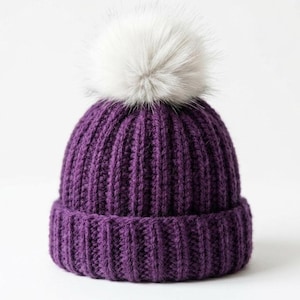 May include: A knitted purple beanie with a ribbed design and a large, fluffy white pom-pom on top. The hat is made of a soft, warm material, perfect for cold weather. The beanie is a stylish winter accessory.