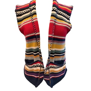 May include: A colorful, open-front sweater with horizontal stripes in red, blue, yellow, and white. The sweater has two pockets and a unique stitched design along the edges. The sleeves are short, and the bottom hem is a deep navy blue.