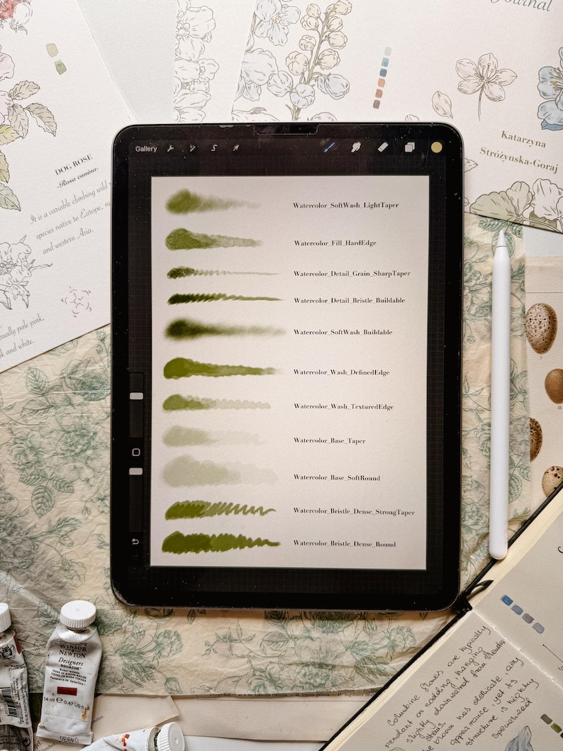 May include: A digital tablet displaying a Procreate brush set interface with ten green watercolor stroke samples. Each stroke is labeled with text including Watercolor SoftWash LightTaper, Fill HardEdge, Detail Grain SharpTaper, and Bristle Dense Round.