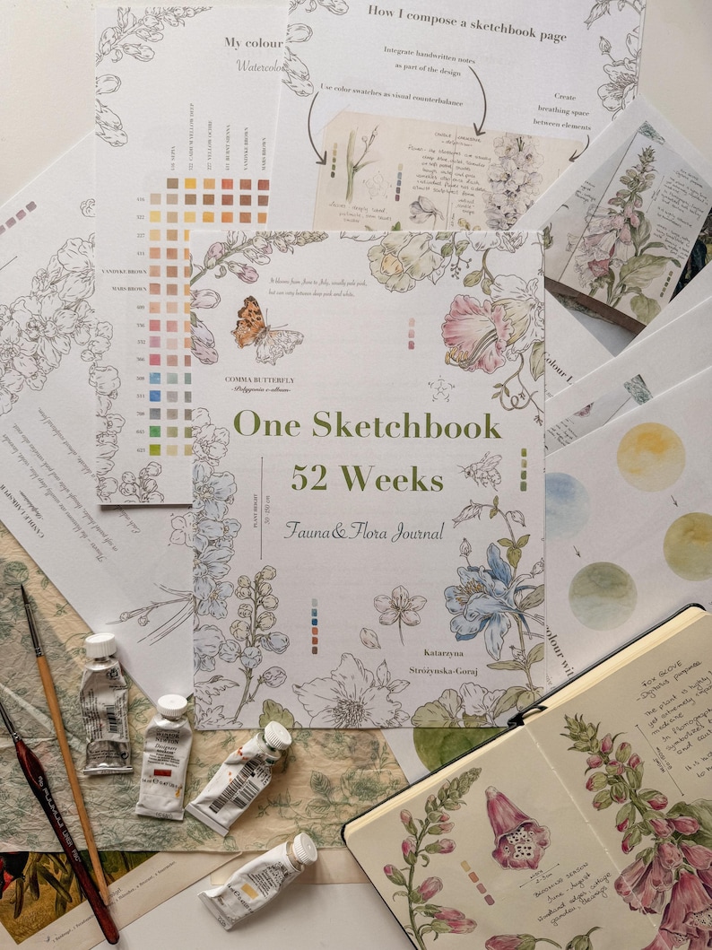 May include: A sketchbook titled One Sketchbook 52 Weeks Fauna & Flora Journal by Katarzyna Strzynska-Goraj, featuring botanical illustrations of flowers and a butterfly, surrounded by watercolor paint tubes, brushes, and instructional pages.