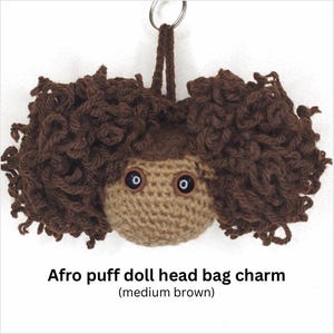 May include: A medium brown crocheted doll head bag charm with dark brown curly hair. The doll has button eyes and a loop for hanging. The text "Afro puff doll head bag charm (medium brown)" is at the bottom.