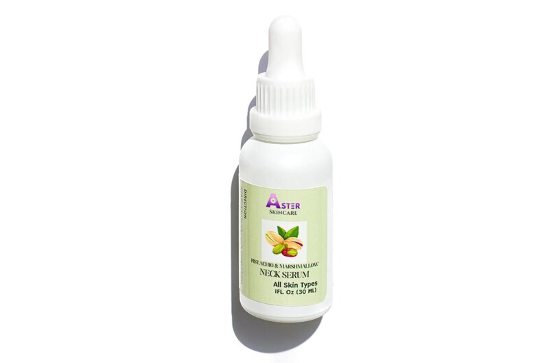 May include: White bottle of Aster Skincare Pistachio & Marshmallow Neck Serum. The label features a pistachio and leaf graphic. The bottle has a dropper top and contains 1 fl oz (30 ml) of serum. The label states "All Skin Types."