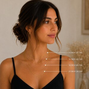 May include: A necklace length guide featuring four gold chains of varying lengths. Text labels indicate 14 inches (35 cm), 16 inches (40 cm), 18 inches (45 cm), and 20 inches (50 cm). The graphic displays the chains layered on a neck.