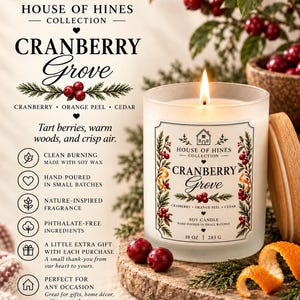 May include: A 10 oz soy candle in a frosted glass jar with a wooden lid, labeled House of Hines Collection Cranberry Grove. The label features botanical illustrations of cranberries and cedar, with text detailing soy wax and small batch pouring.