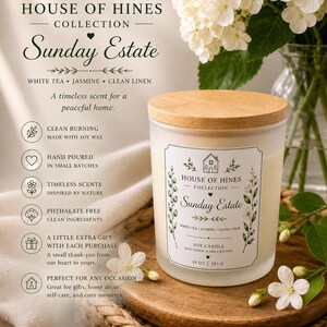 May include: A soy candle from the House of Hines Collection, labelled "Sunday Estate." The candle is in a frosted glass jar with a wooden lid. The label includes the scent notes: white tea, jasmine, and clean linen. The candle is 283 g.
