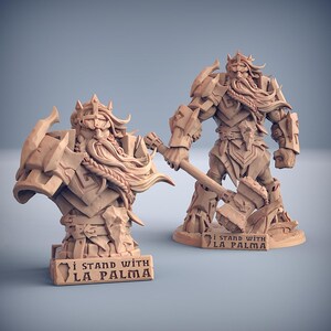 Könnte beinhalten: Zwei beige Fantasy-Figuren. Eine ist eine Büste, die andere eine vollständige Figur, beide zeigen einen bärtigen Krieger mit Krone und Rüstung. Die volle Figur hält einen Hammer. Beide haben den Text "I STAND WITH LA PALMA" auf ihren Sockeln.