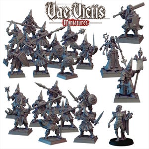 Può includere: Una collezione di figurine in miniatura, tra cui figure incappucciate con armi, una figura femminile con più braccia e una statua di un uomo con una lira. Le figurine sono su basi quadrate. Il testo "Vae Victis Miniatures" è in alto.