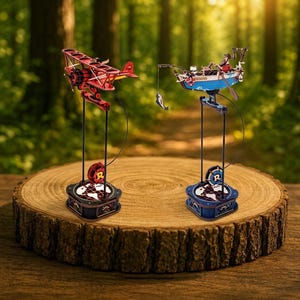 May include: Two wooden model kits: a red biplane and a blue fishing boat. Each model is mounted on a stand with a globe-themed base. The biplane has red wings and a propeller. The fishing boat features a fisherman and a caught fish.