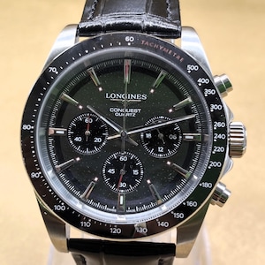 Könnte beinhalten: Eine Longines Conquest Quartz Chronographenuhr mit schwarzem Zifferblatt, silberfarbenen Zeigern und Stundenmarkierungen sowie drei Hilfszifferblättern. Die Uhr verfügt über eine schwarze Tachymeterlünette und ein schwarzes Lederarmband.
