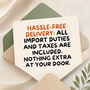 Op de afbeelding: Een rechthoekige witte kaart met afgeronde hoeken en oranje en zwarte tekst: HASSLE-FREE DELIVERY: ALL IMPORT DUTIES AND TAXES ARE INCLUDED. NOTHING EXTRA AT YOUR DOOR. De kaart ligt bovenop groene en beige papieren enveloppen.