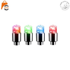 May include: Four cylindrical valve cap lights with metallic silver bases and translucent tops. Each cap emits a distinct glow: one orange-pink, one green, one blue, and one red. These small, battery-operated accessories feature a smooth finish.