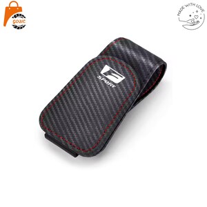 May include: A black carbon fibre textured belt clip pouch featuring a white logo with the text SPORT and red stitching along the edges. The pouch has a rounded flap closure and a sturdy construction designed for carrying small personal items securely.