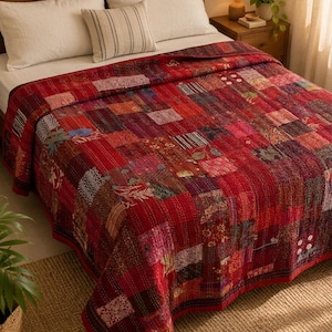 May include: A rectangular patchwork quilt featuring a vibrant red color palette with various fabric squares in shades of maroon, burgundy, and crimson. The quilt displays intricate kantha stitching patterns throughout the surface.