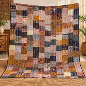 May include: A rectangular patchwork quilt featuring a variety of fabric squares in shades of orange, blue, pink, yellow, and brown. The quilt displays diverse floral, geometric, and paisley patterns with visible white running stitch embroidery.
