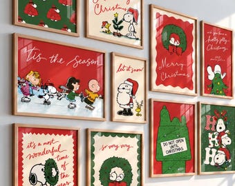 May include: A gallery wall of ten framed Peanuts-themed Christmas prints featuring Snoopy, Charlie Brown, and Lucy. The artwork displays festive red and green color palettes with holiday text like Merry Christmas, Tis the Season, and Let it snow.