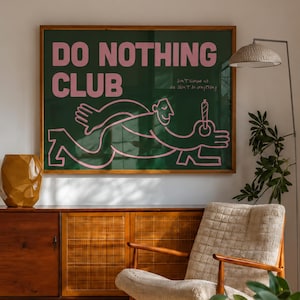 Puede incluir: Una lámina de arte mural rectangular en un marco de madera con fondo verde oscuro, texto rosa que dice DO NOTHING CLUB y un dibujo lineal rosa de una persona sosteniendo un cigarrillo encendido. Incluye texto más pequeño bajo el título.