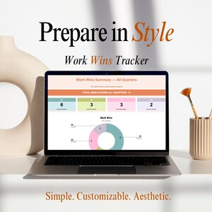 May include: A laptop displaying a "Work Wins Tracker" with a summary of quarterly wins. The screen shows a chart and data, with the text "Prepare in Style" at the top. The laptop is on a white surface, with a vase and paintbrushes nearby.
