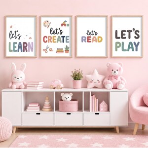 May include: Four framed wall art prints featuring the text let's LEARN, let's CREATE, let's READ, and LET'S PLAY in colourful, playful typography. The prints include small illustrations of art supplies, books, and a plant, displayed in light wood frames.