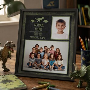 May include: A framed school photo with a chalkboard-style design, featuring a child's portrait and a group photo. The frame includes space for the school name, teacher's name, school year, and student's name. Dinosaur figurines and a notebook are on the wooden surface.