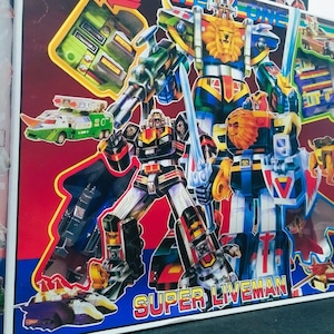 May include: A rectangular toy box featuring colorful illustrations of Super Liveman robot figures in red, blue, yellow, and green. The box displays multiple robot characters, a sword, and various vehicle components. The text SUPER LIVEMAN is printed in large yellow and red letters at the bottom.