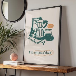 May include: A framed wall art print featuring a dark green line drawing of a moka pot, a glass, and a bag of coffee beans. The text "Coffee" appears in an orange bubble, and the phrase "It's coffee o'clock" is written in dark green script.