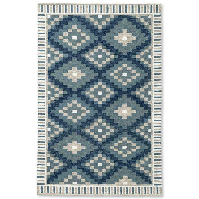 May include: Rectangular area rug with a geometric pattern in shades of blue and beige. The rug features a repeating diamond design in varying shades of blue, with beige accents. A striped border in beige and white frames the patterned center.