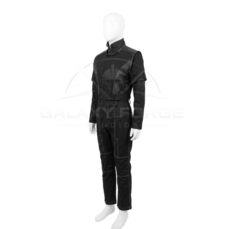 Pu&ograve; includere: Tuta nera con collo alto e maniche lunghe. L'outfit presenta un corpetto aderente, una cintura e pantaloni a gamba dritta con cuciture a vista. Il manichino indossa scarpe bianche. Lo stile generale &egrave; futuristico.