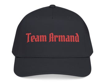 May include: A black baseball cap featuring the text Team Armand embroidered in red thread across the front panel. The cap has a structured crown, a curved brim, and a button at the top centre. The design is centred on the front of the hat.