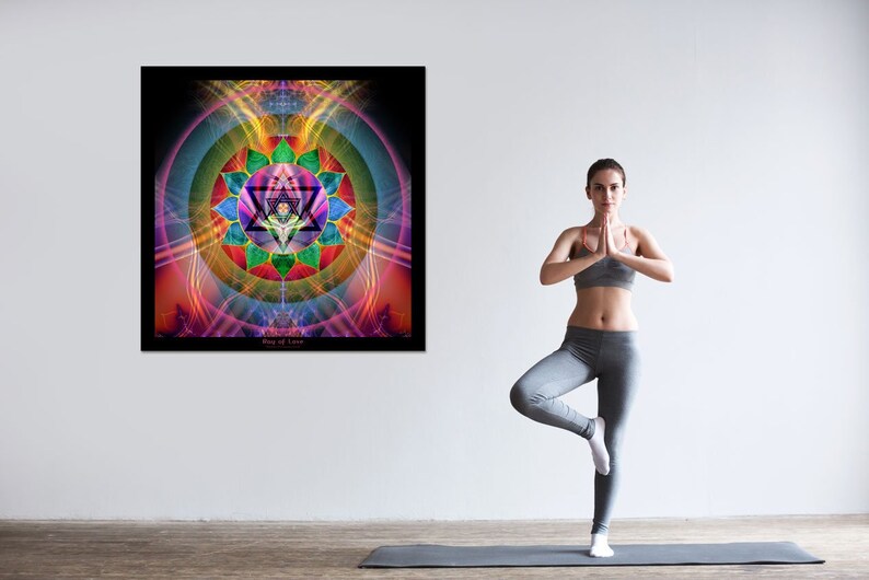 May include: A woman in grey yoga pants and a grey sports bra stands on a yoga mat in a tree pose. Behind her is a framed print of a colorful mandala with the text "Ring of Love".
