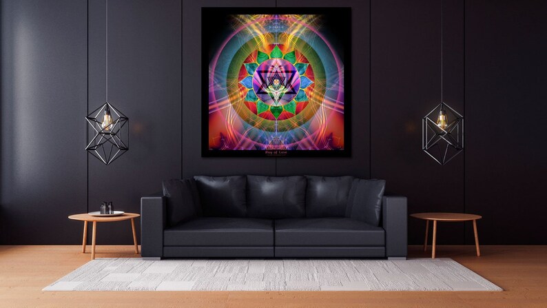 May include: A black leather couch with a colorful geometric mandala print hanging on the wall behind it. The mandala is surrounded by a ring of light and has a star in the center. Two black geometric pendant lights hang from the ceiling.