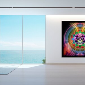 May include: A colorful abstract mandala art print with geometric shapes and vibrant colors, including pink, purple, green, blue, and yellow, hanging on a white wall in a modern living room with a large window overlooking the ocean.