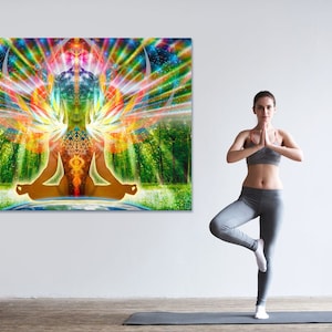 Może przedstawiać: Kobieta w szarych spodniach do jogi i szarym sportowym biustonoszu stoi w pozycji drzewa na macie do jogi. Za nią znajduje się kolorowa ścienna tapiseria przedstawiająca medytującą postać z tęczową aurą.