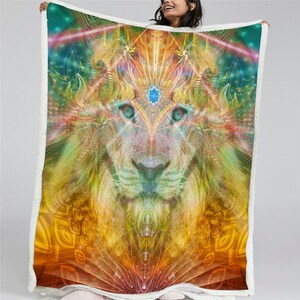 Pu&ograve; includere: Una coperta in pile colorata con il viso di un leone con un terzo occhio al centro della fronte. Il viso del leone &egrave; circondato da intricati motivi e vortici di colore, tra cui sfumature di giallo, arancione, verde, blu e viola.