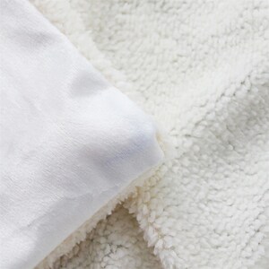 May include: Close-up of a white blanket with a soft, smooth surface on one side and a textured, fluffy surface on the other. The blanket is folded, revealing both textures and creating a cozy, inviting feel.