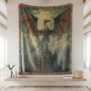 May include: A woven tapestry featuring a dragon perched atop a castle, set against a cloudy sky. The dragon has outstretched wings with reddish-brown accents. The tapestry has a fringed border and a vintage aesthetic.