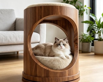 Può includere: Un letto per gatti in legno con un design circolare e un morbido cuscino beige all'interno. Un gatto soffice riposa all'interno del letto. Il letto ha una parte superiore rotonda con un cuscino beige. Il letto per gatti è in legno.