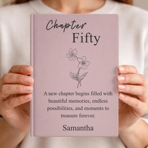 May include: A light pink journal with the words "Chapter Fifty" and a floral illustration. The text "A new chapter begins filled with beautiful memories..." is below, with the name "Samantha" at the bottom.