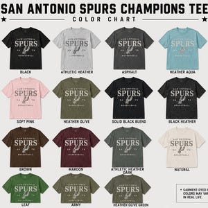 May include: A color chart displaying twenty-three short-sleeve t-shirts in various colors, each featuring the text SAN ANTONIO SPURS CHAMPIONS TEE at the top and a graphic with the text SAN ANTONIO SPURS SA TX BASKETBALL on the front of each shirt.