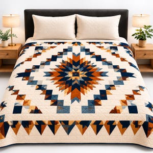 May include: A cream-colored quilt with a geometric starburst design in shades of navy blue, rust, and tan. The quilt is on a bed with matching cream-colored pillows. The bed is flanked by wooden nightstands with lamps and plants.