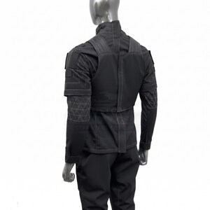 May include: Black tactical uniform, including a jacket with a high collar, shoulder straps, and geometric patterned sleeves. The uniform also features matching pants. The outfit is displayed on a mannequin.