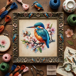 May include: A detailed cross-stitch of a kingfisher bird with blue, orange, and teal plumage, set in a decorative frame. The image is surrounded by embroidery threads, small bird ornaments, and craft tools, suggesting a crafting theme.