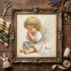 Puede incluir: Un punto de cruz enmarcado de un ángel querubín con rizos rubios, una corona floral y alas blancas. El ángel está en posición de oración, vistiendo un vestido blanco. El marco dorado y ornamentado está rodeado de materiales de artesanía, incluyendo hilo de bordar y tijeras.