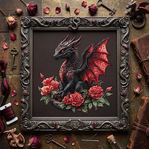 May include: A framed cross-stitch of a black dragon with red wings and eyes, surrounded by red roses. The frame is dark brown with ornate details. The image is set against a rustic wooden background with keys, dried roses, and spools of thread.