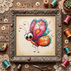May include: A framed cross-stitch of a whimsical butterfly with pink, orange, and teal wings. The butterfly has large eyes and is surrounded by craft supplies like spools of thread, lace, and a small bird figurine. The frame is bronze-colored.