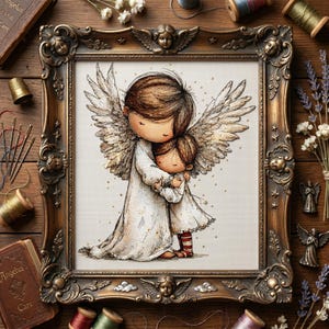 May include: A framed cross-stitch artwork depicts two embracing figures with angel wings. The figures are dressed in white robes, with one figure hugging the other. The ornate, gold-colored frame features cherub accents. The artwork is surrounded by sewing supplies.