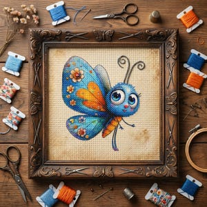 May include: A framed cross-stitch of a cartoon butterfly with blue, orange, and yellow details. The butterfly is centered in a brown wooden frame. Spools of thread, scissors, and other craft supplies surround the frame on a wooden surface.