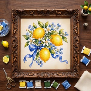May include: A framed cross-stitch embroidery featuring three bright yellow lemons, white blossoms, and small blue flowers tied with a blue ribbon. The ornate dark brown frame includes carved cherub and lion motifs, surrounded by embroidery supplies.