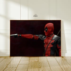 May include: A framed artwork featuring the character Deadpool in a red and black costume, holding a gun. The artwork has a dark background and is set in a gold frame. The character is in a shooting pose.
