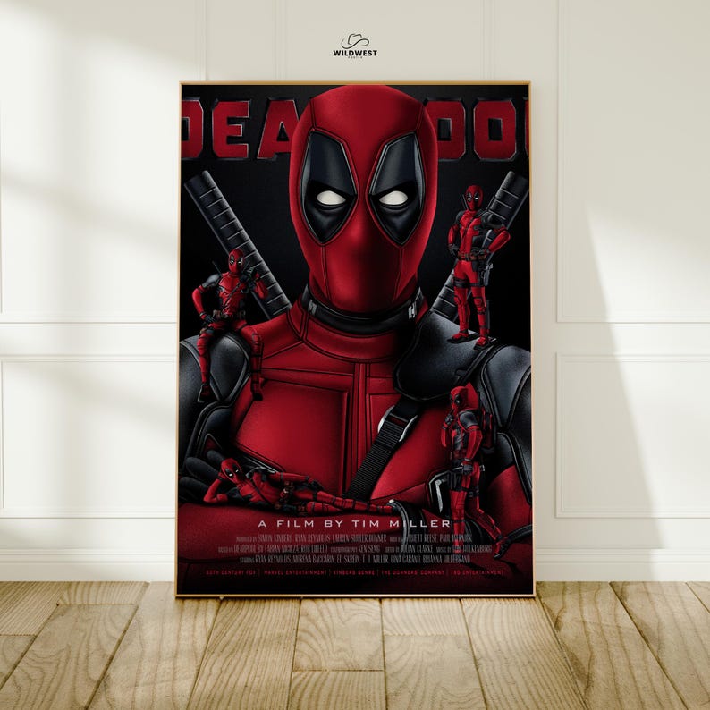 May include: A framed poster featuring the character Deadpool in a red and black costume. The poster has the word "DEADPOOL" in large red letters at the top. Several miniature Deadpool figures are positioned around the main figure. The text "A FILM BY TIM MILLER" is at the bottom.