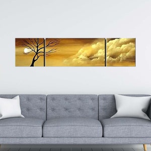 May include: A three-piece canvas wall art set featuring a silhouette of a tree against a sunset sky with clouds. The artwork is in shades of gold, brown, and white.
